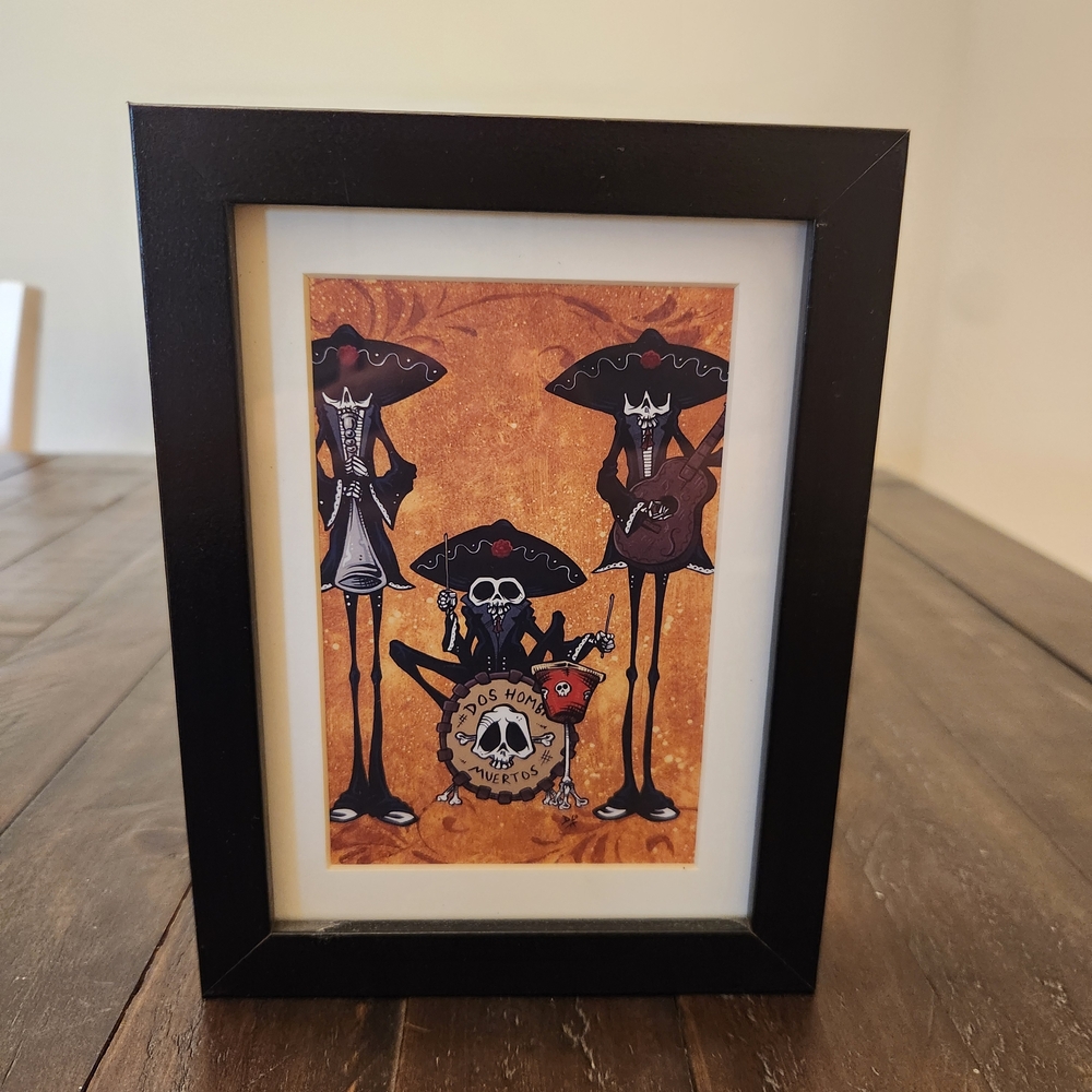 A framed print of the "Dos Hombres Muertos" (Two Dead Guys) band by David Lozeau